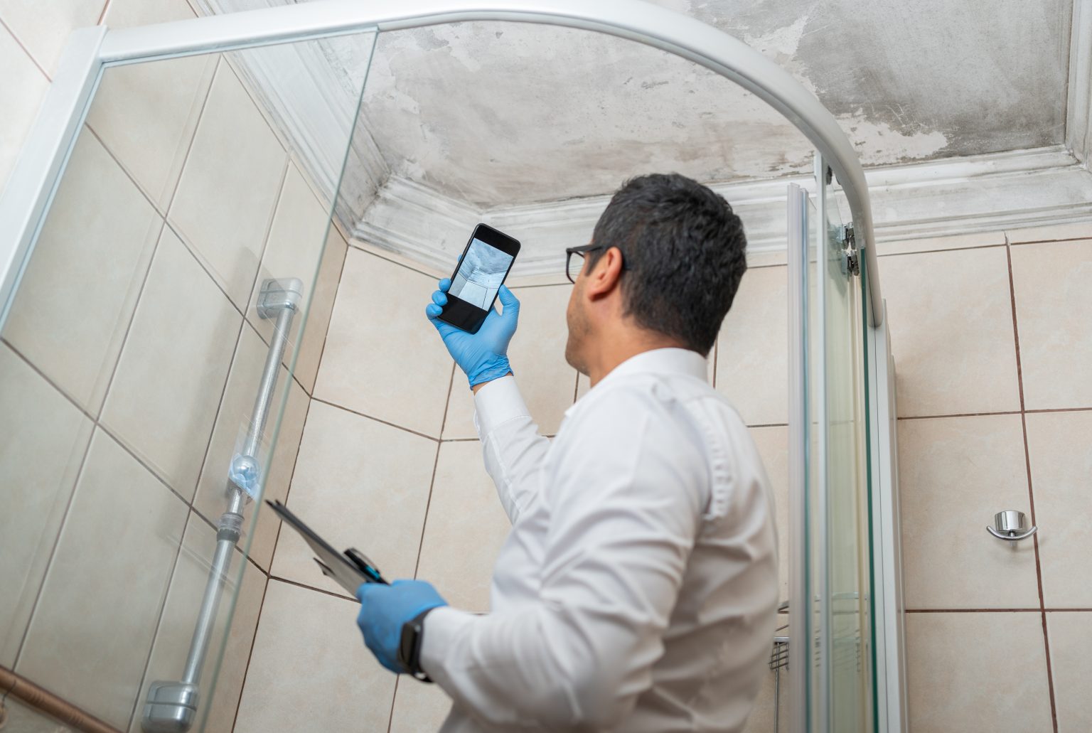 mold remediation expert taking picture of mold in the bathroom.